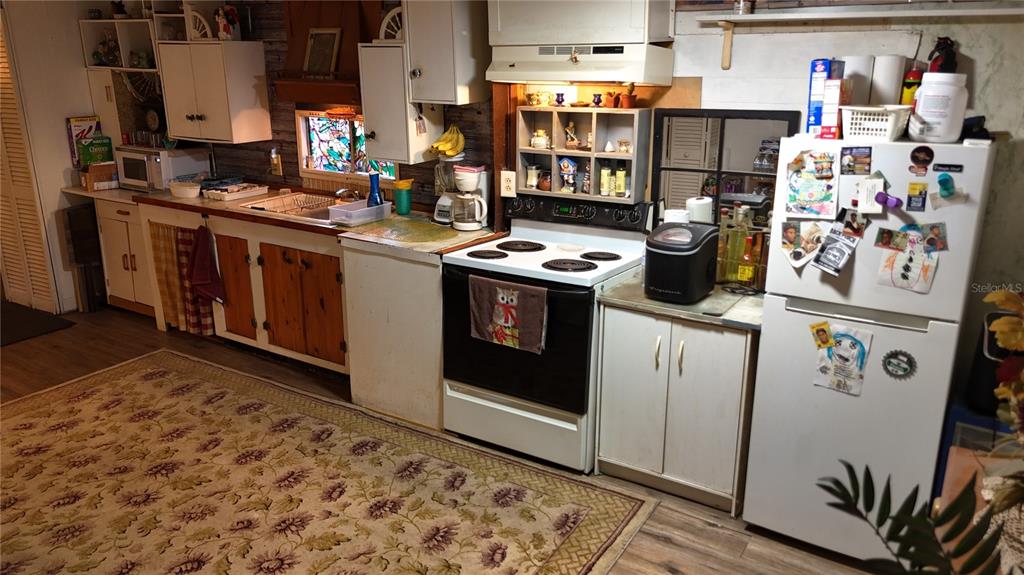 16935 Southeast 101st Avenue Road Summerfield, FL 34491 - Photo 4 of 17 a kitchen with stainless steel appliances granite countertop a stove a sink and a refrigerator