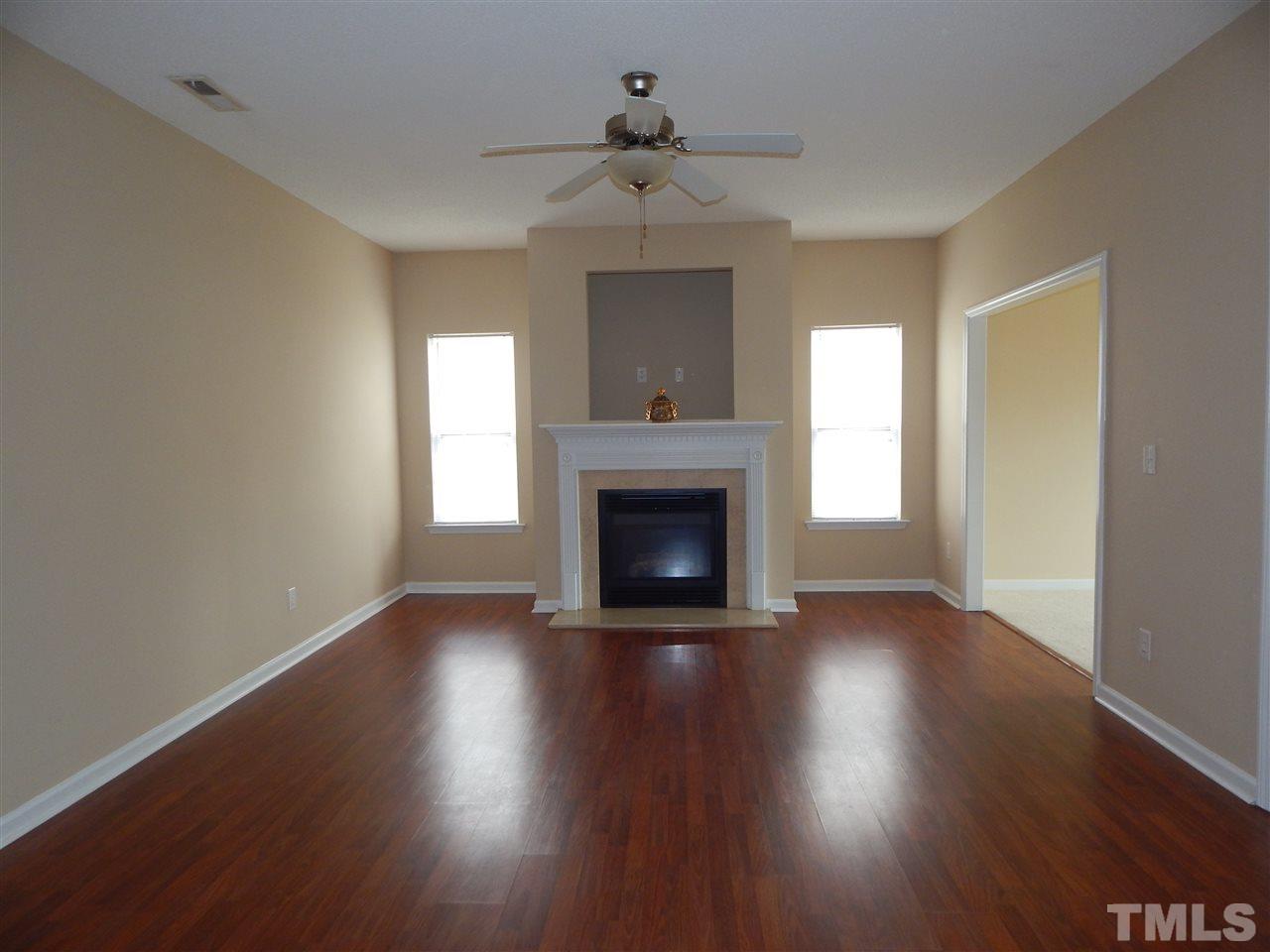4808 Cutstone Court Raleigh, NC 27610 - Photo 2 of 14 a view of an empty room with wooden floor a fireplace and a window