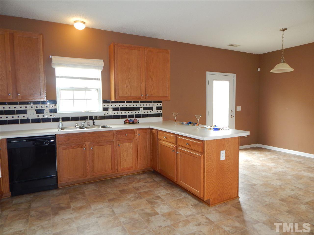4808 Cutstone Court Raleigh, NC 27610 - Photo 4 of 14 a kitchen with stainless steel appliances granite countertop a stove a sink and a refrigerator
