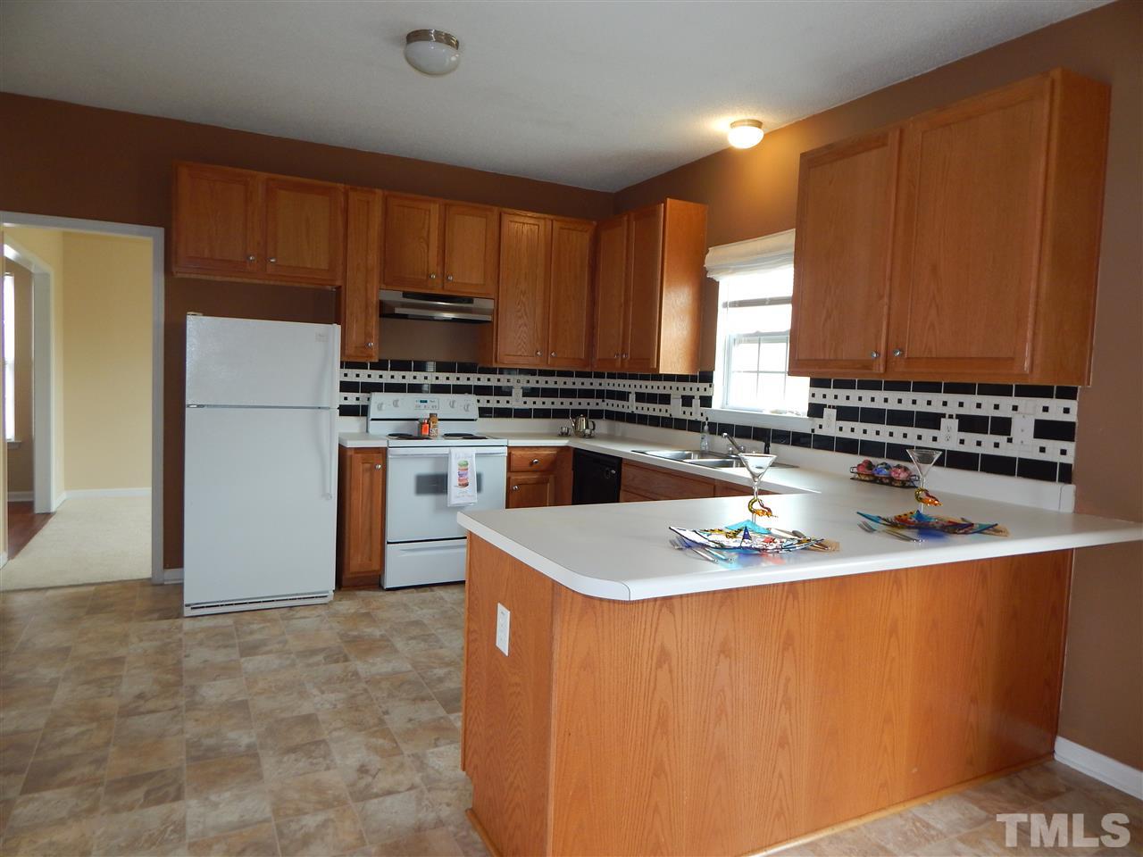 4808 Cutstone Court Raleigh, NC 27610 - Photo 5 of 14 a kitchen with stainless steel appliances granite countertop a stove a sink dishwasher and a refrigerator