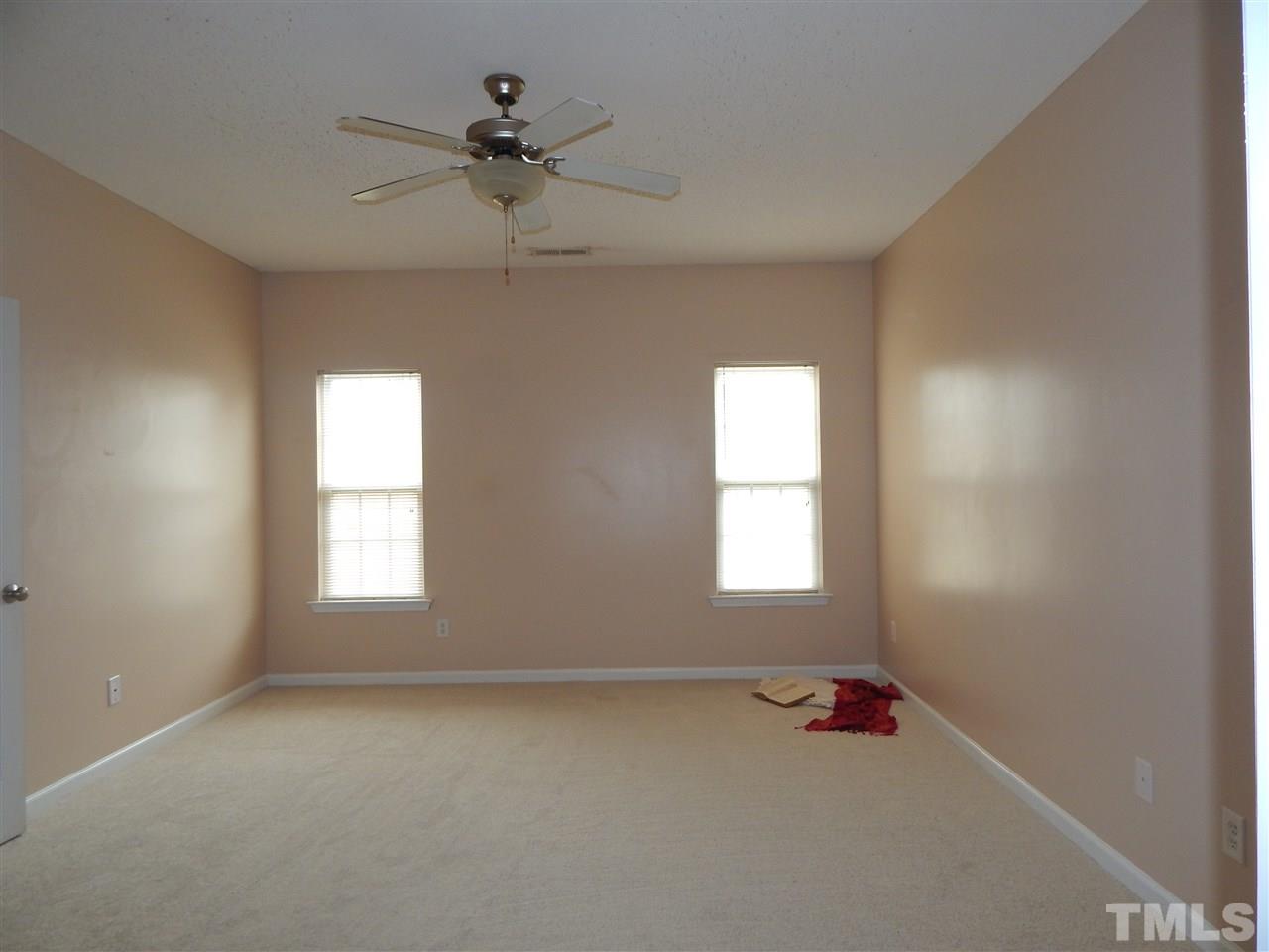 4808 Cutstone Court Raleigh, NC 27610 - Photo 7 of 14 an empty room with a window and a ceiling fan