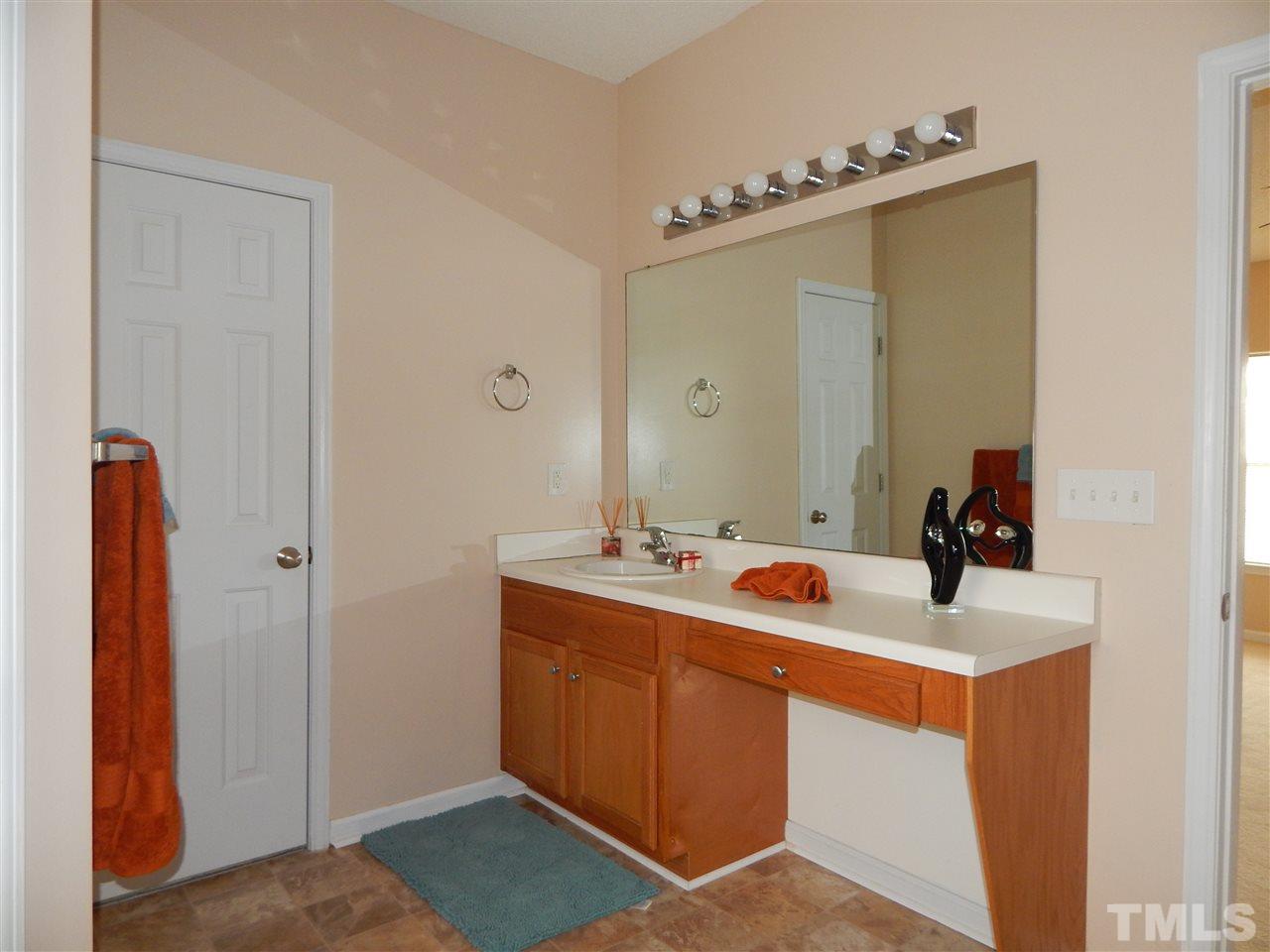 4808 Cutstone Court Raleigh, NC 27610 - Photo 8 of 14 a bathroom with a sink and mirror