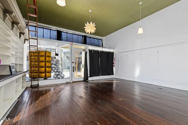 a living room with furniture a flat screen tv and kitchen view