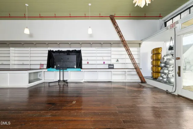 a kitchen with stainless steel appliances a dining table chairs stove a sink and a refrigerator