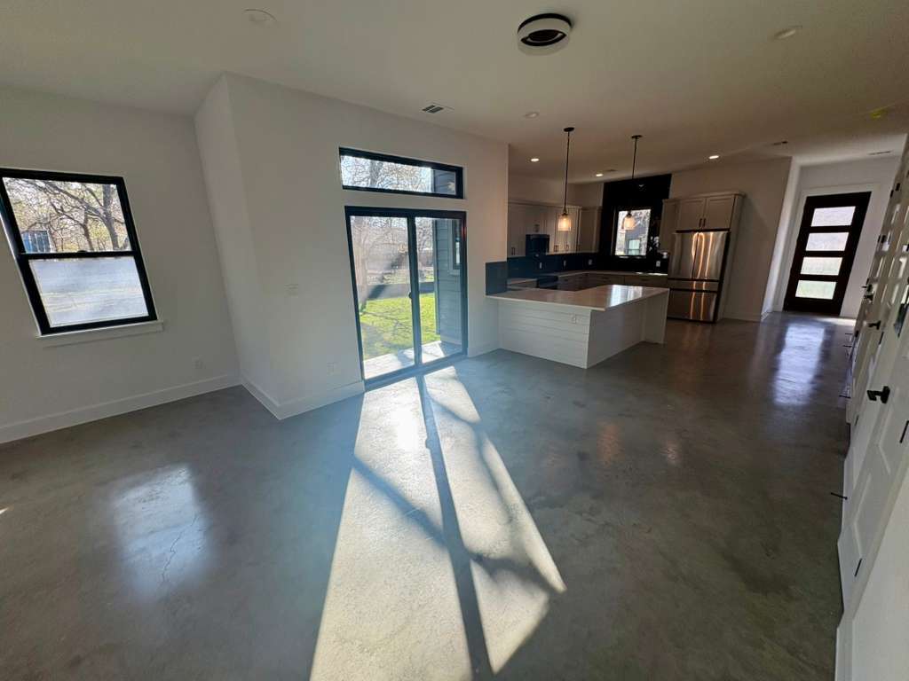 10209 Gail Road Austin, TX 78748 - Photo 38 of 38 Kitchen featuring finished concrete floors, freestanding refrigerator, open floor plan, decorative light fixtures, and recessed lighting