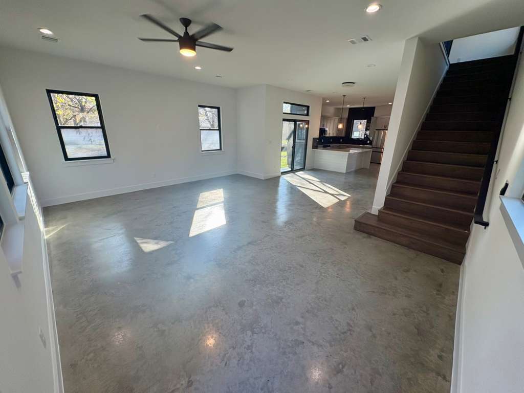 10209 Gail Road Austin, TX 78748 - Photo 15 of 38 Unfurnished living room with finished concrete floors, ceiling fan, recessed lighting, and stairway