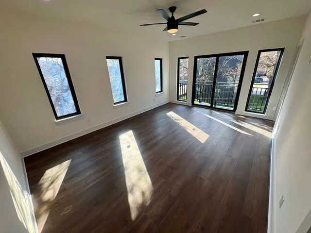 an empty room with wooden floor and a window