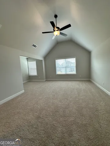 an empty room with windows and fan