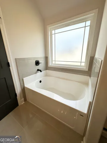 a bathroom with bathtub and window