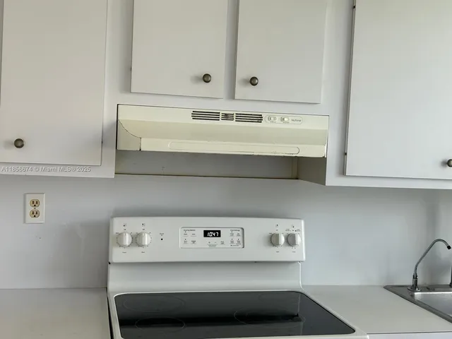 a kitchen with a white cabinets and a window