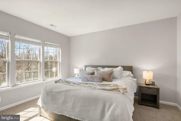 a large bed sitting in a bedroom next to a window