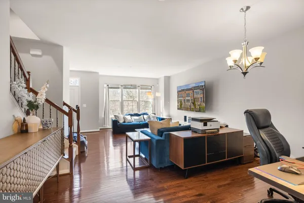 a living room with furniture chandelier and wooden floor