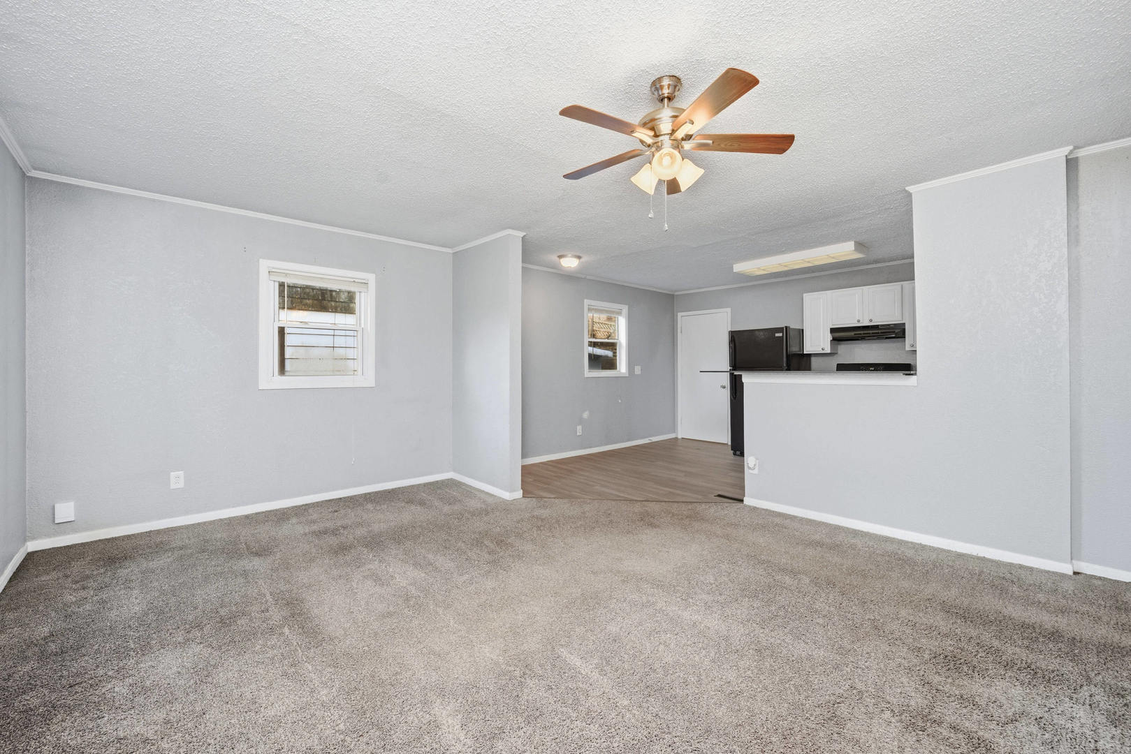 3128 Indian Road Davenport, IA 52802 - Photo 4 of 23 a view of a livingroom with a ceiling fan a kitchen space and a window