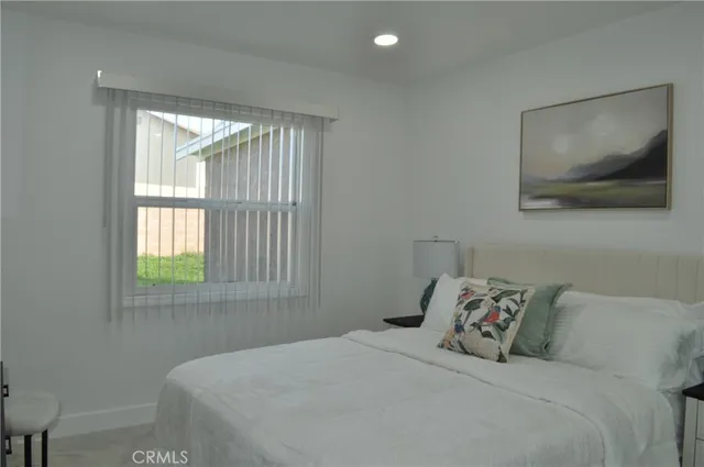 a bedroom with a bed and a painting on the wall