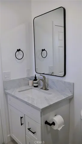 a bathroom with a granite countertop sink and a mirror