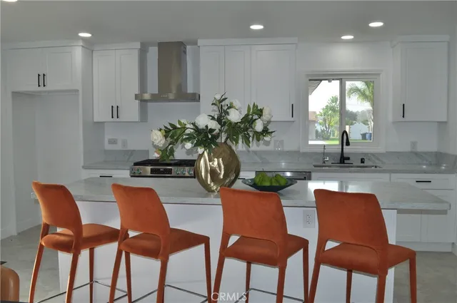 a dining room filled chandelier and kitchen view