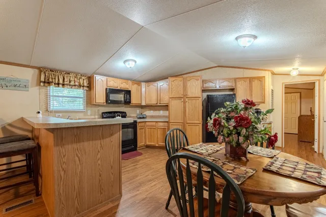 a kitchen with sink a refrigerator and chairs