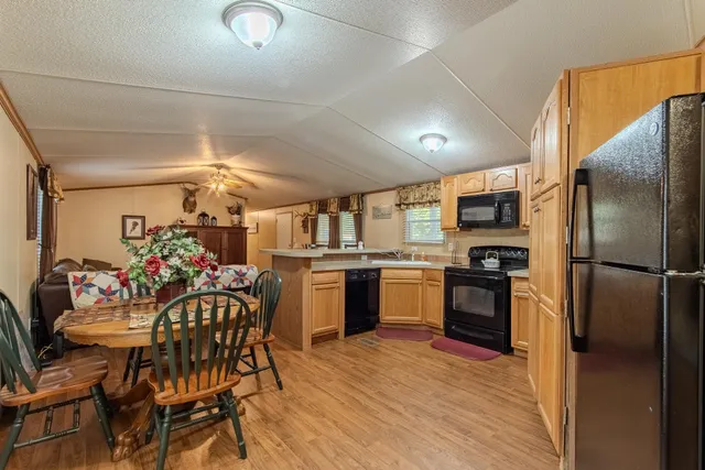 a kitchen with granite countertop a refrigerator and wooden floor
