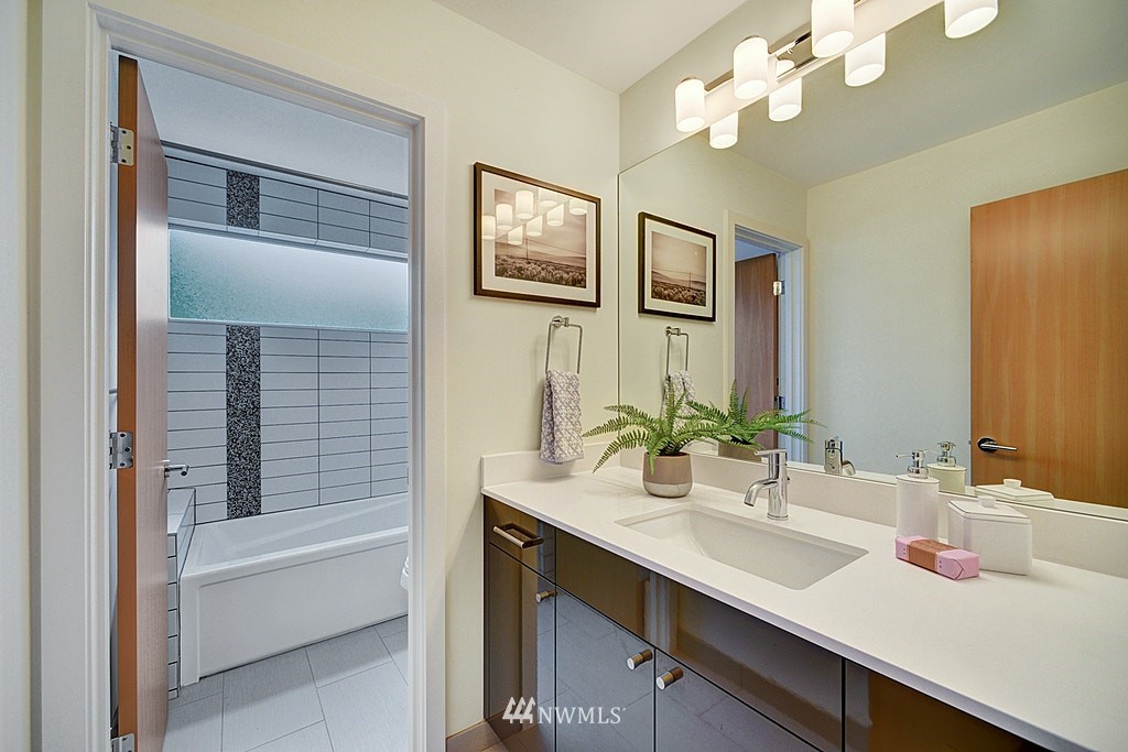 933 16th Avenue, Unit A Seattle, WA 98122 - Photo 12 of 19 a bathroom with a sink a tub and a mirror
