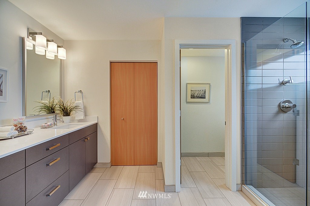 933 16th Avenue, Unit A Seattle, WA 98122 - Photo 15 of 19 a spacious bathroom with a granite countertop sink mirror and shower