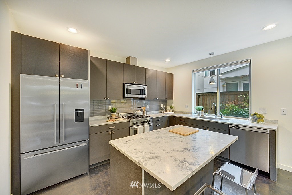 933 16th Avenue, Unit A Seattle, WA 98122 - Photo 7 of 19 a kitchen with a refrigerator a sink and a stove top oven