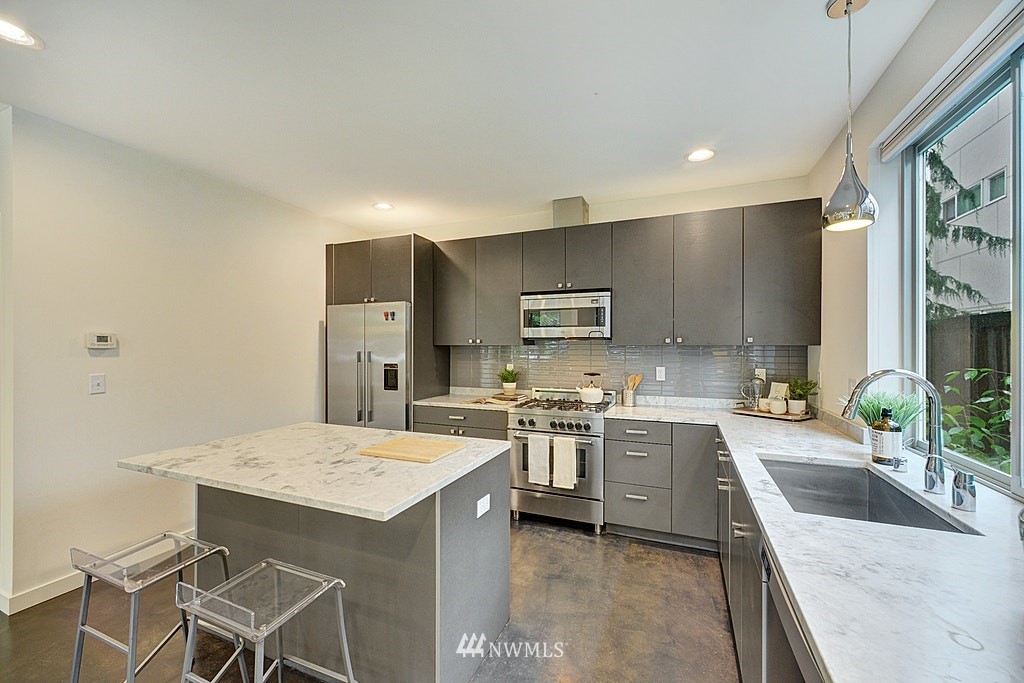 933 16th Avenue, Unit A Seattle, WA 98122 - Photo 8 of 19 a kitchen with a sink stove top oven and refrigerator