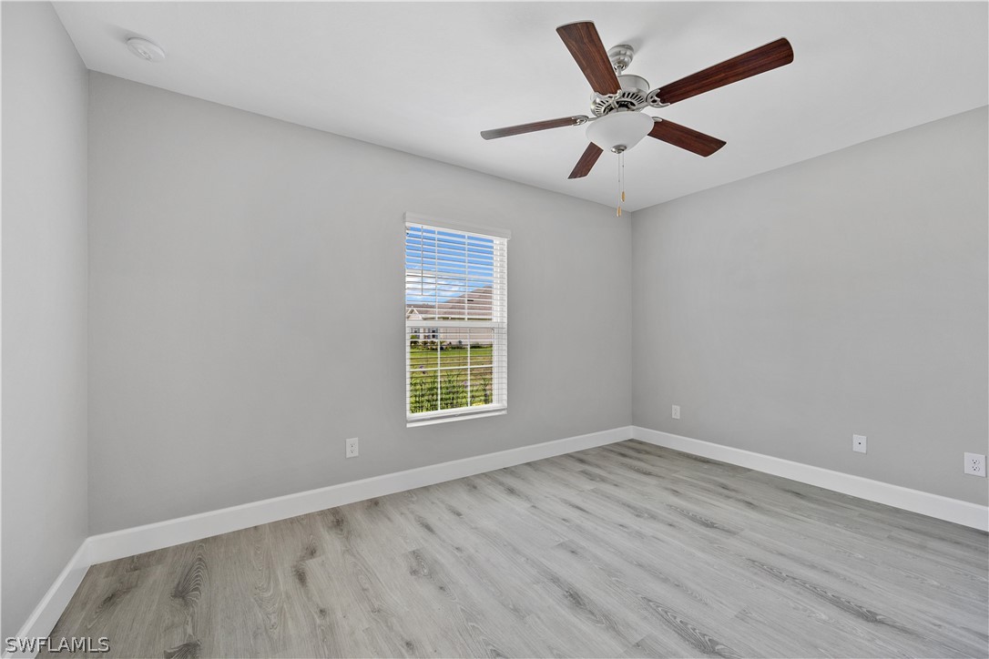 16582 Becasse Drive Punta Gorda, FL 33955 - Photo 21 of 32 an empty room with wooden floor and ceiling fan