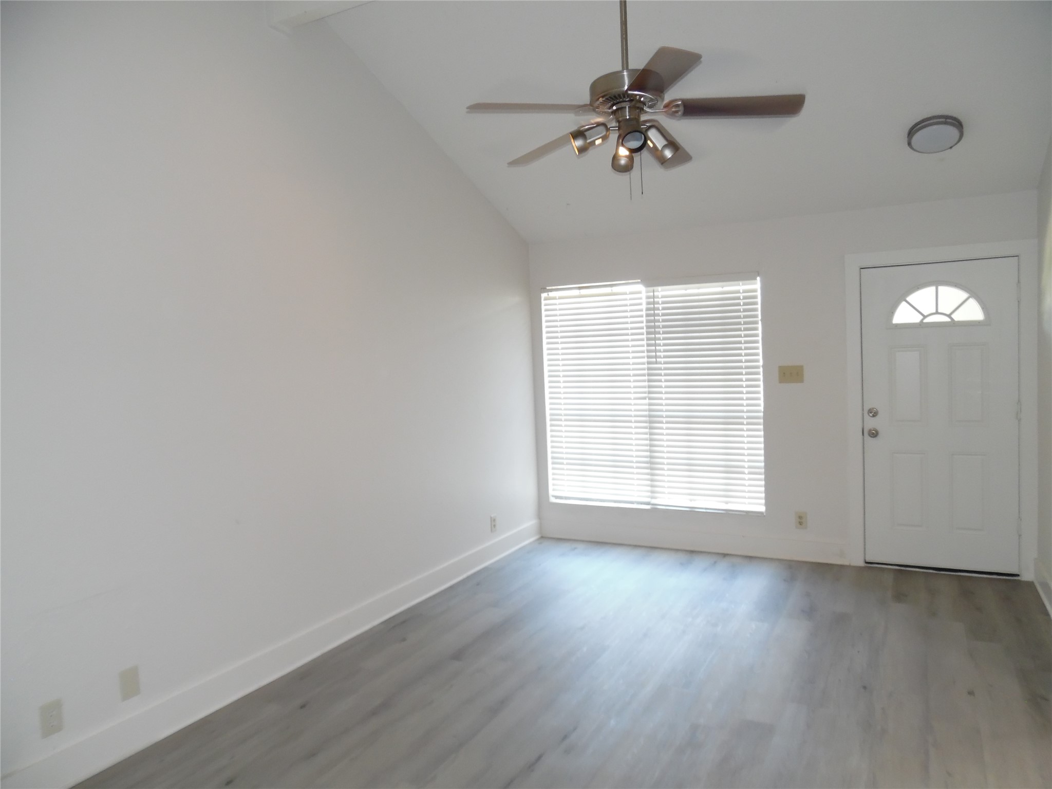 7400 Dixie Drive, Unit B Austin, TX 78744 - Photo 5 of 15 Spacious room featuring a vaulted ceiling and contemporary wood-finish flooring