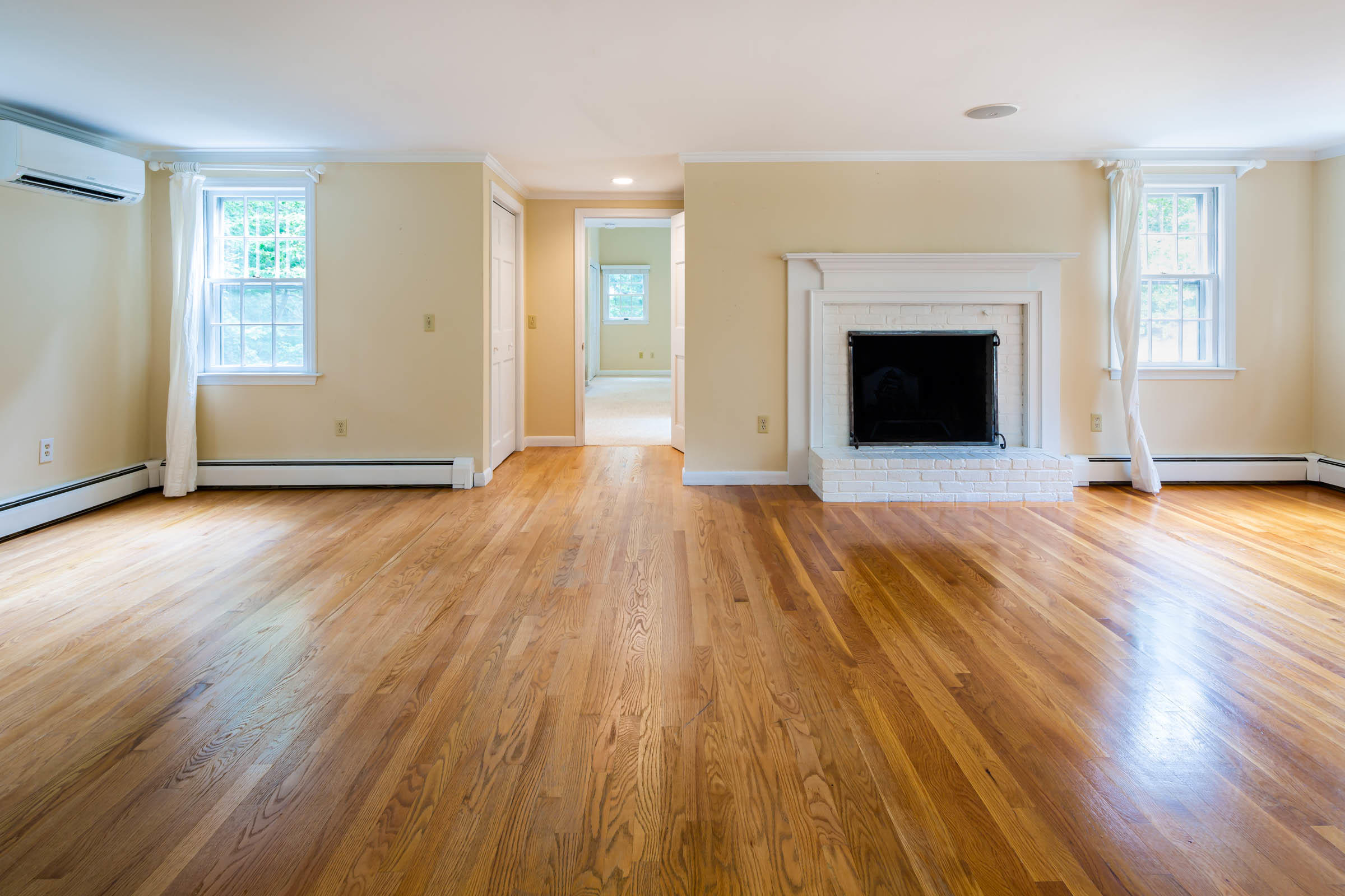 176 Monument Road Orleans, MA 02653 - Photo 19 of 55 an empty room with wooden floor fireplace and windows