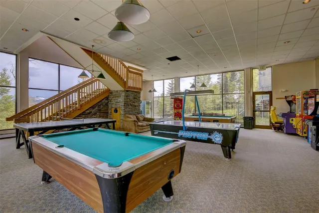 a room with pool table windows and furniture