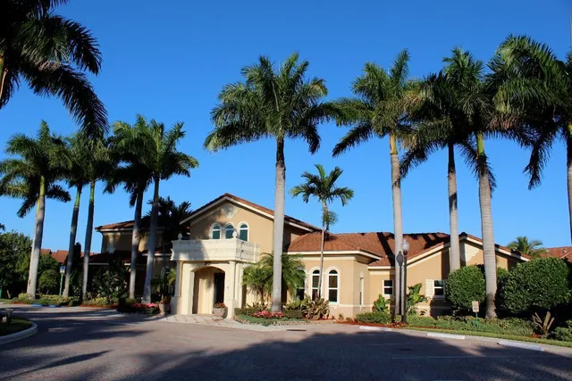 a front view of a house with a palm tree