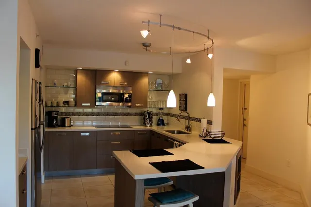 a kitchen with kitchen island a sink appliances and cabinets