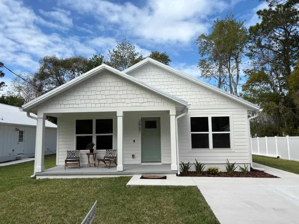 a front view of house with yard and trees in the background