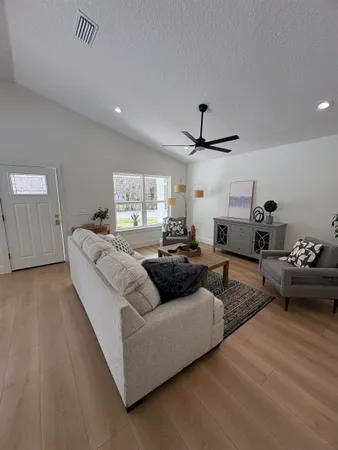 a kitchen with stainless steel appliances kitchen island granite countertop a sink a stove and a wooden floors