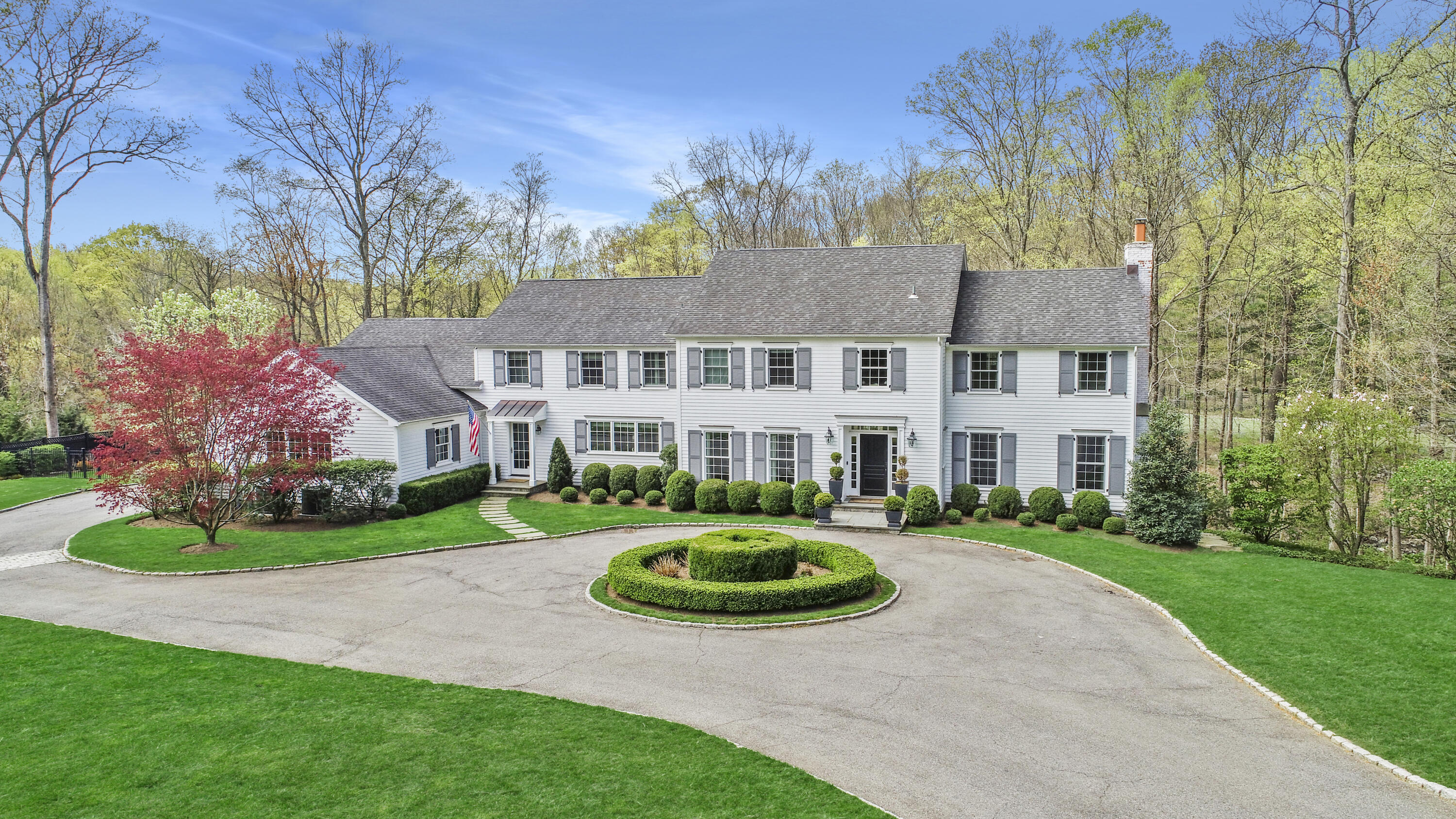 a front view of a house with a garden and trees