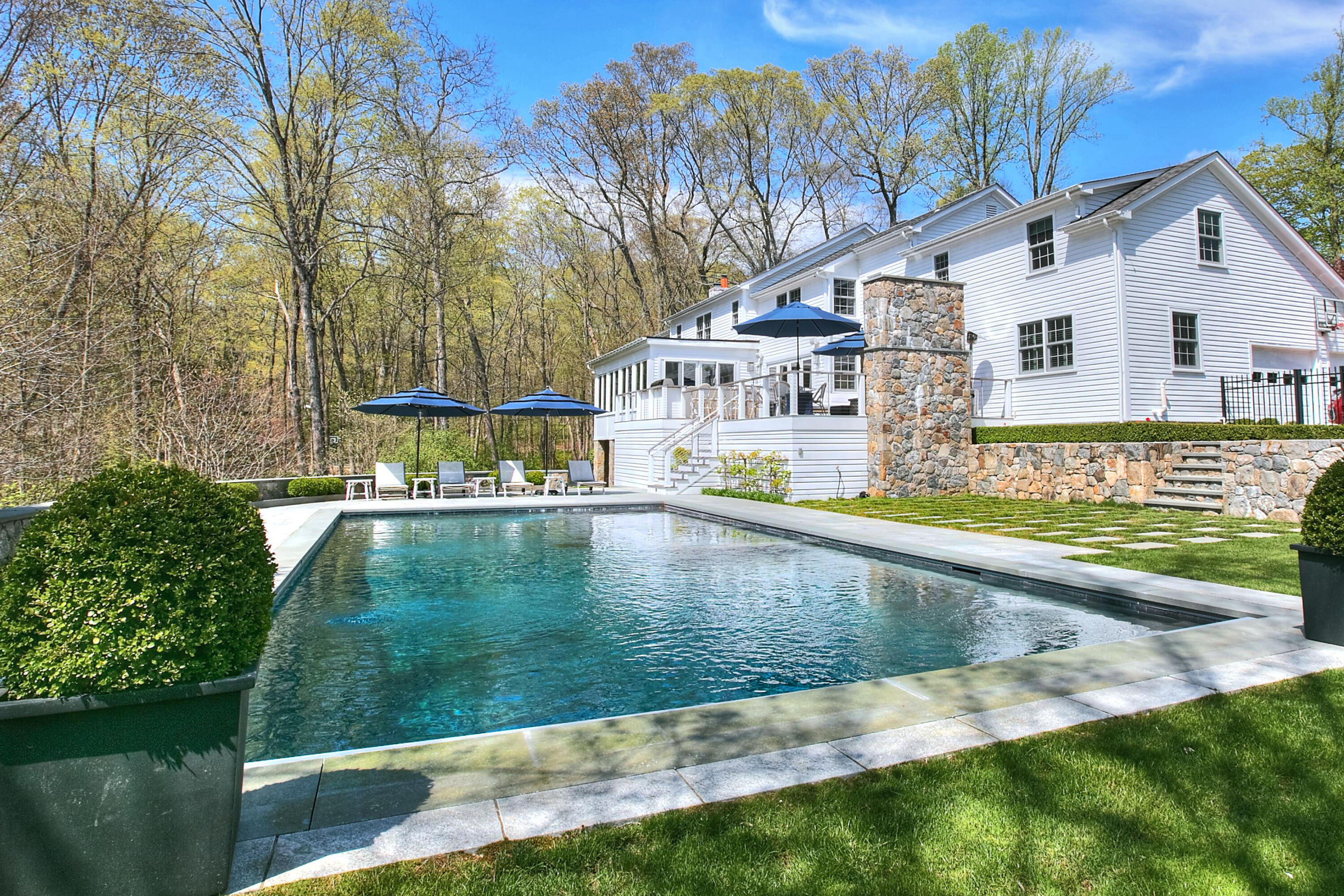 128 Dunning Road New Canaan, CT 06840 - Photo 41 of 49 a view of swimming pool with outdoor seating and trees in the background