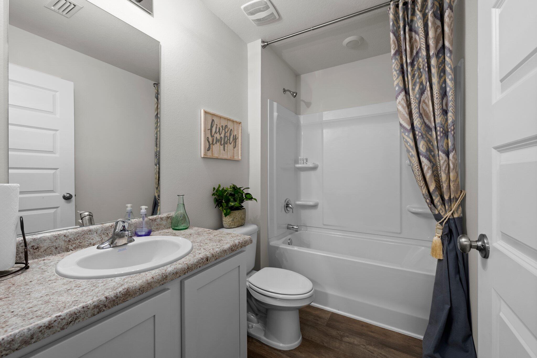 9318 Tara Circle Milton, FL 32583 - Photo 24 of 30 a bathroom with a granite countertop sink toilet and shower