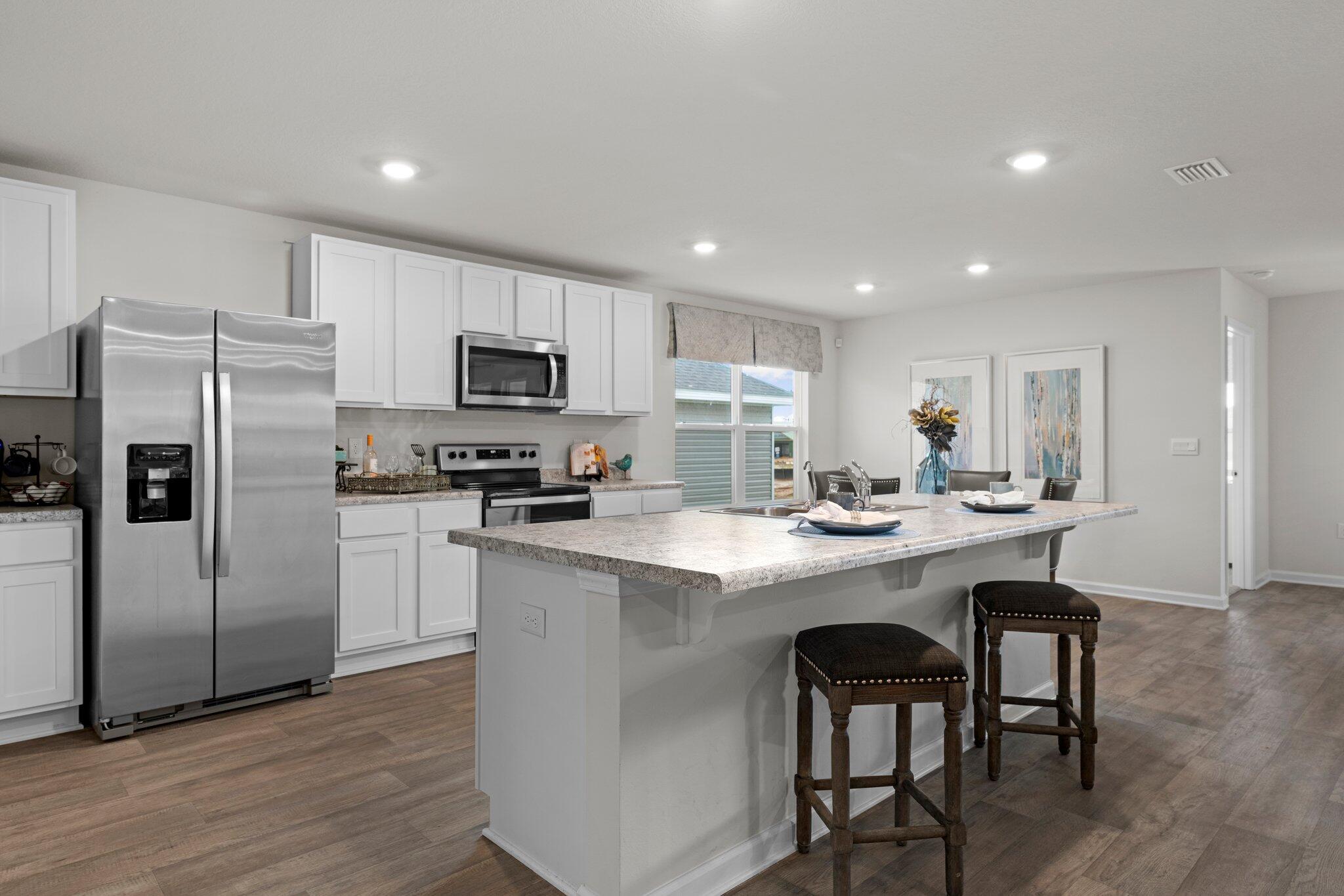 9318 Tara Circle Milton, FL 32583 - Photo 8 of 30 a kitchen with refrigerator cabinets and wooden floor