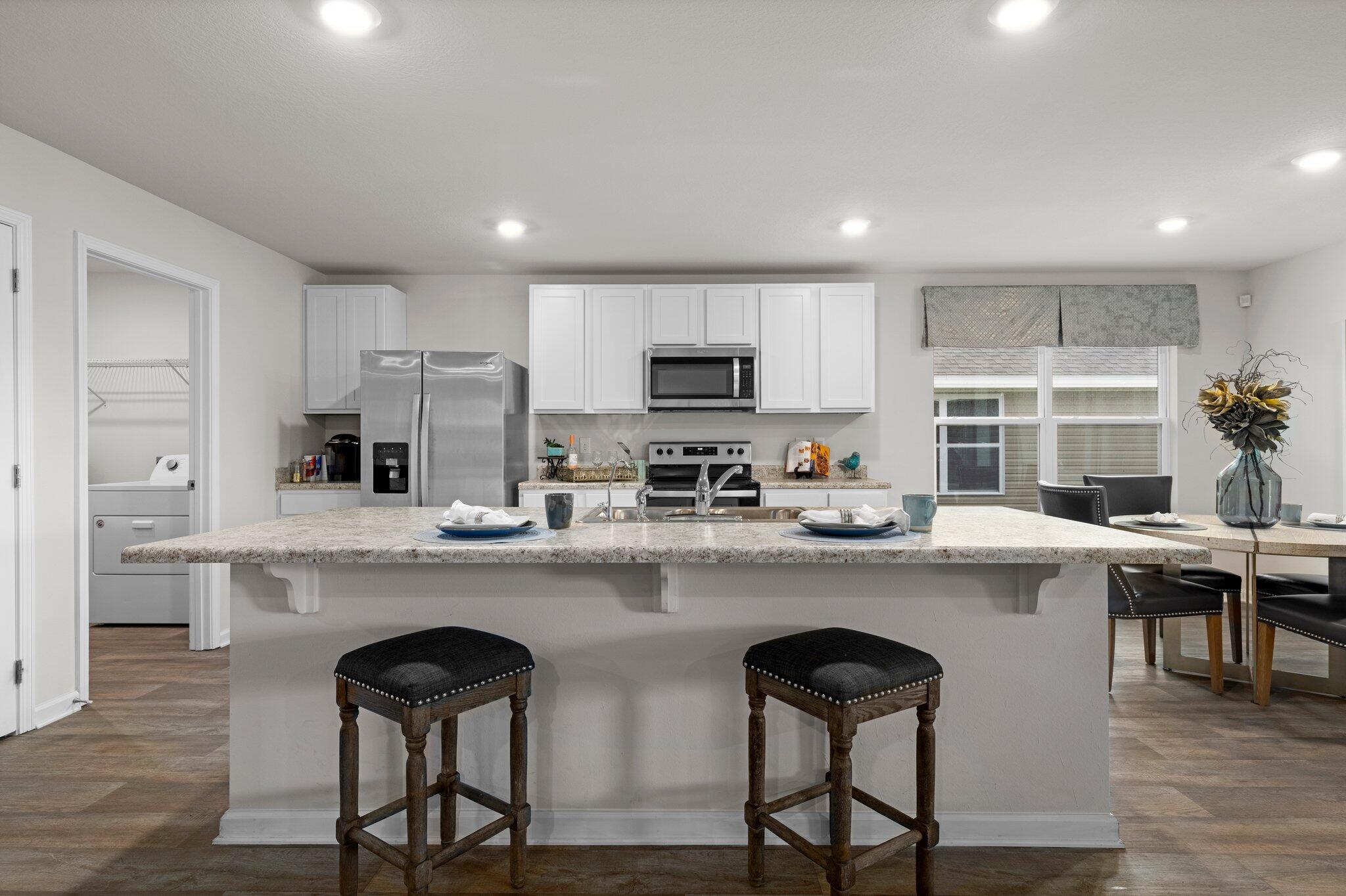9318 Tara Circle Milton, FL 32583 - Photo 9 of 30 a kitchen with refrigerator and chairs