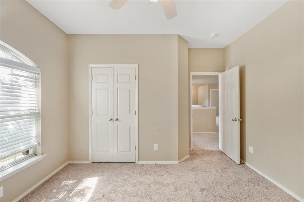 2003 Diamondback Forney, TX 75126 - Photo 25 of 30 Unfurnished bedroom featuring light colored carpet, a closet, multiple windows, and ceiling fan