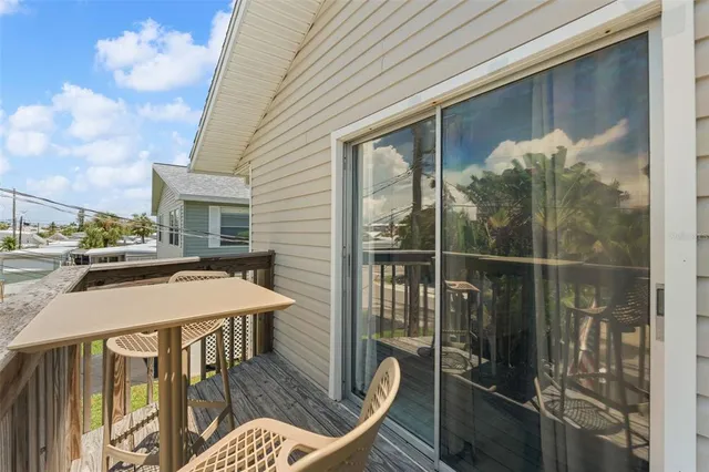 a living room with patio furniture and a wooden floor