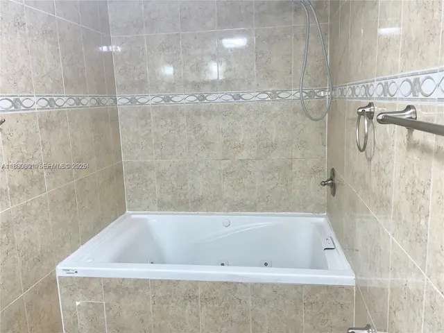 a bathroom with a granite countertop toilet sink and mirror