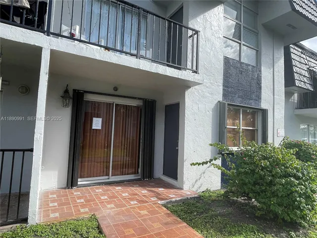 a view of a house with many windows and plants