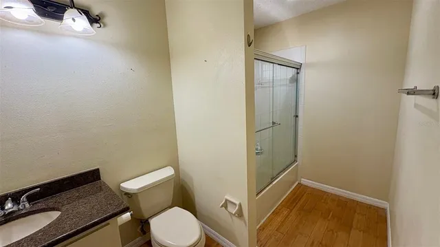 a bathroom with a granite countertop toilet and a sink