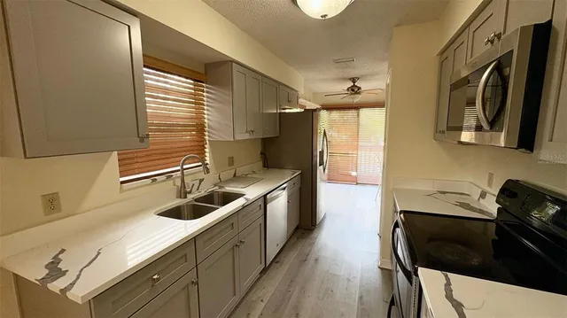 a kitchen with a sink a stove and cabinets