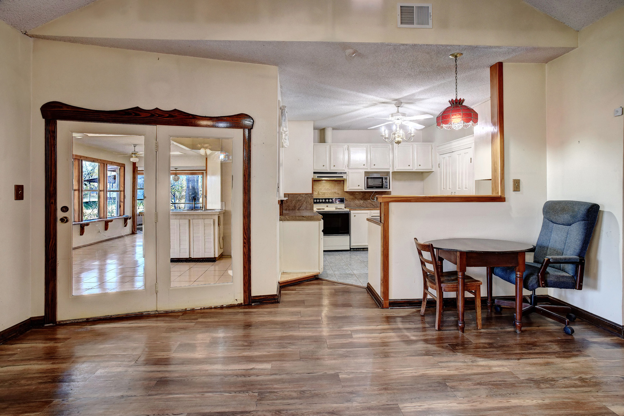 113 My Road Bastrop, TX 78602 - Photo 17 of 35 Kitchen with white cabinets, a textured ceiling, white electric range oven, pendant lighting, and decorative backsplash