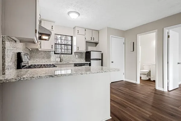 a large bedroom with a bed and a view of living room