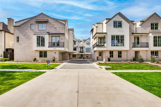 a front view of residential houses with yard and green space
