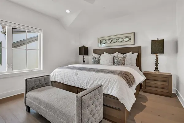 a spacious bedroom with a bed and wooden floor