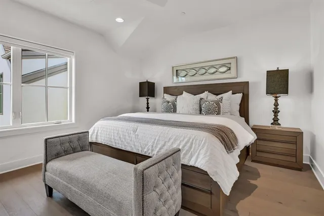 a spacious bedroom with a bed and wooden floor